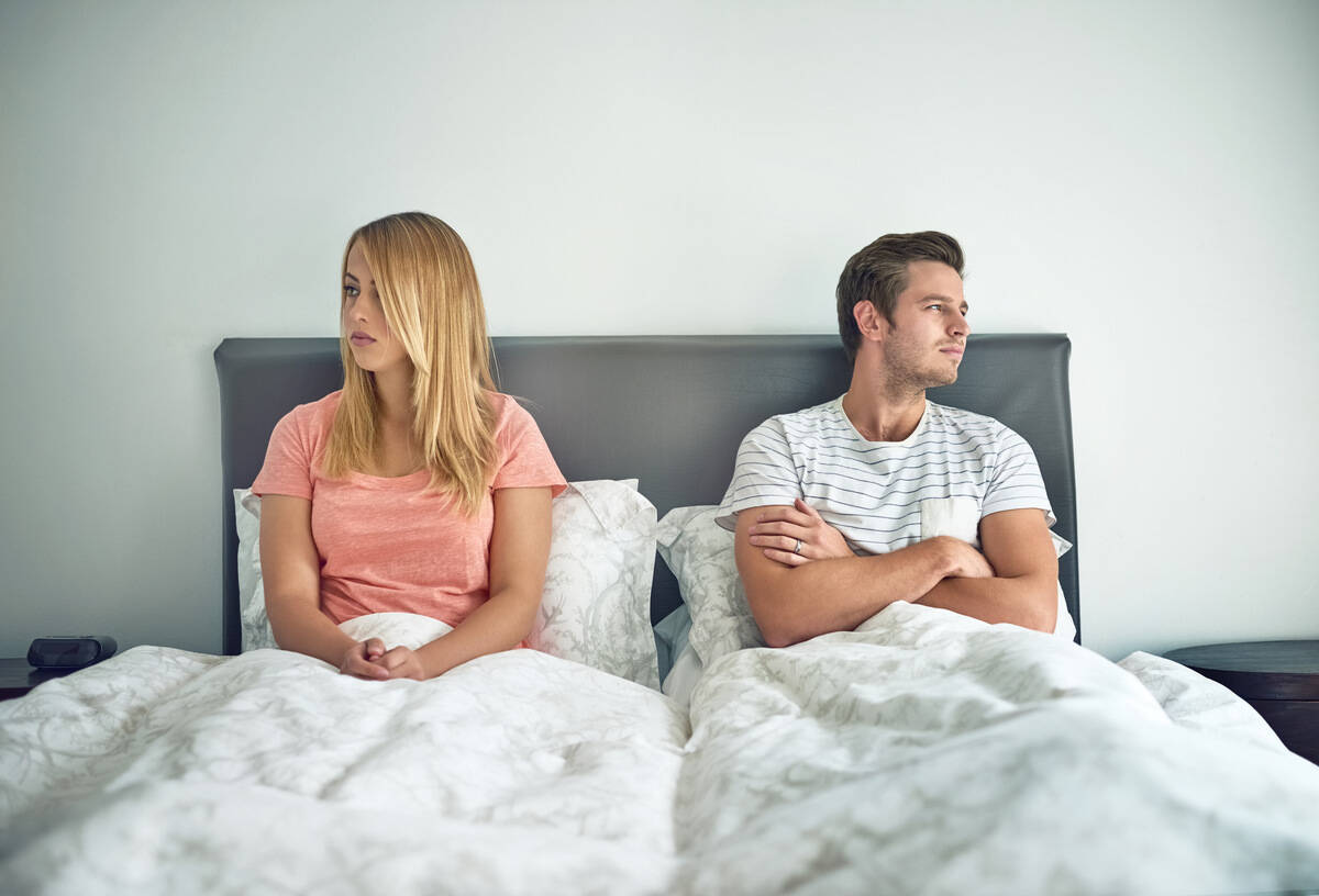 young couple ignoring each other in bed