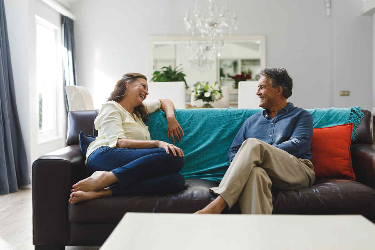 happy senior couple talking on the sofa in the living room